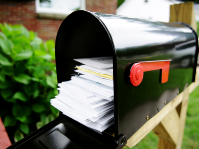 Open black mailbox full of letters with red flag. Inflation, the Economy, and Certified Mail